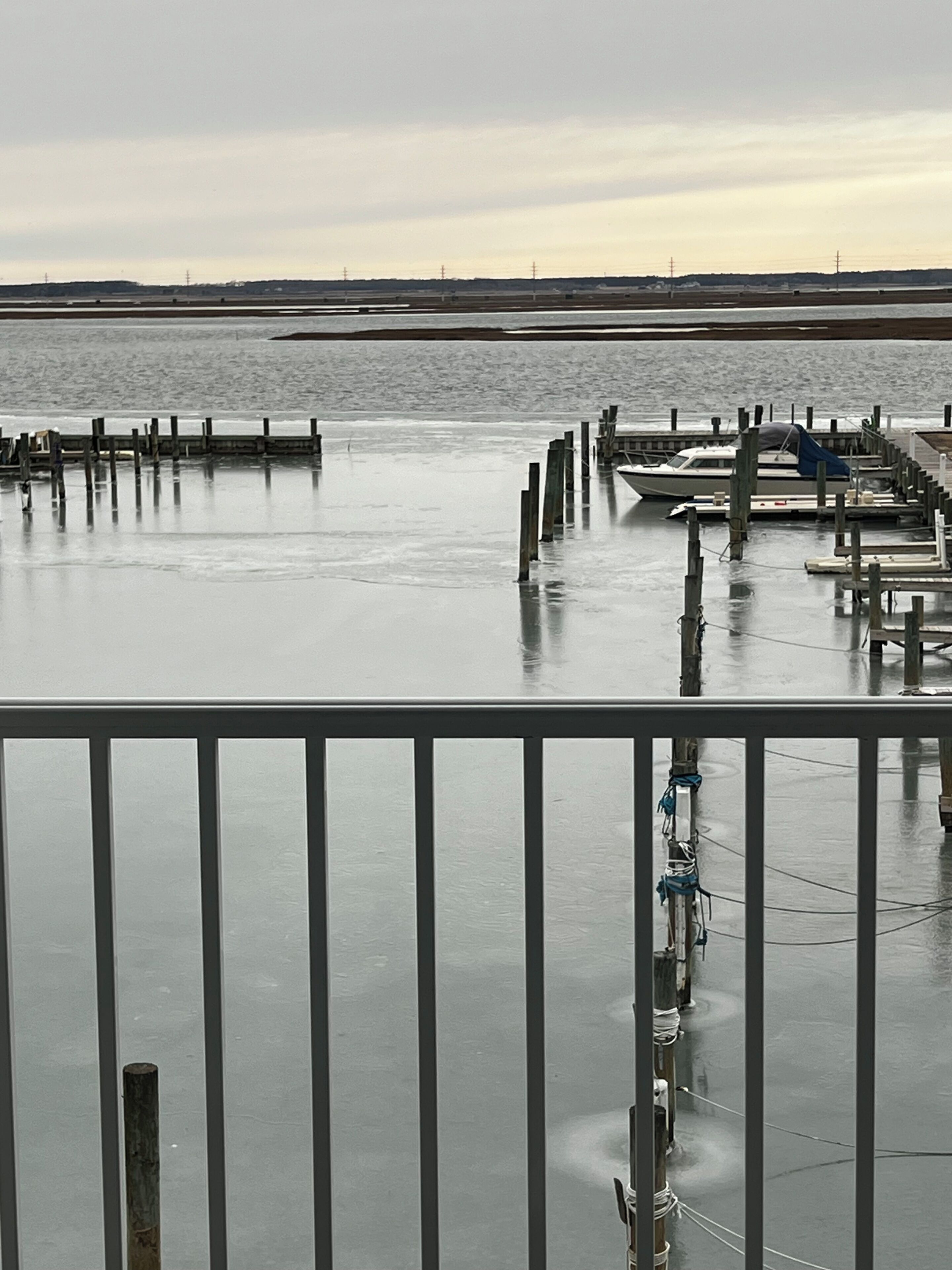 Een steiger aan het water met boten en een houten pier die in het rustige water reikt.