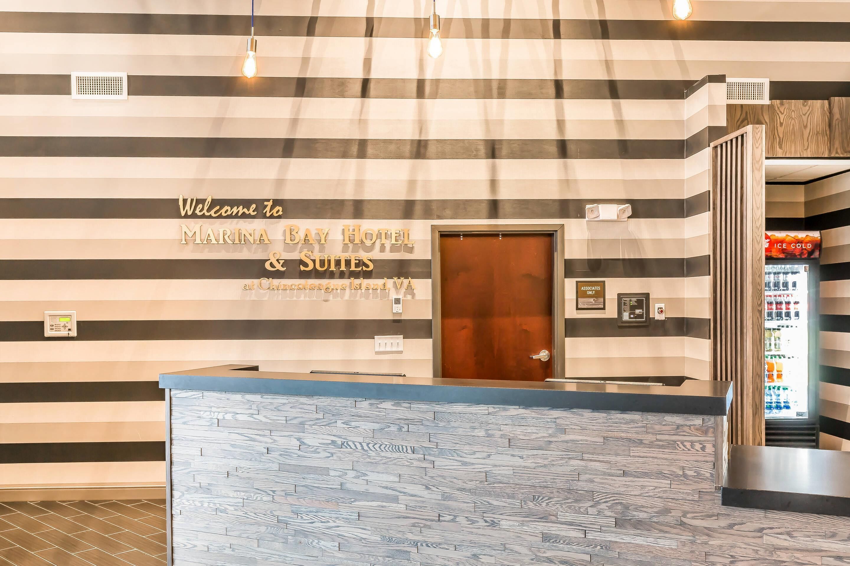 A reception area with a striped wall, a reception desk, and a vending machine.