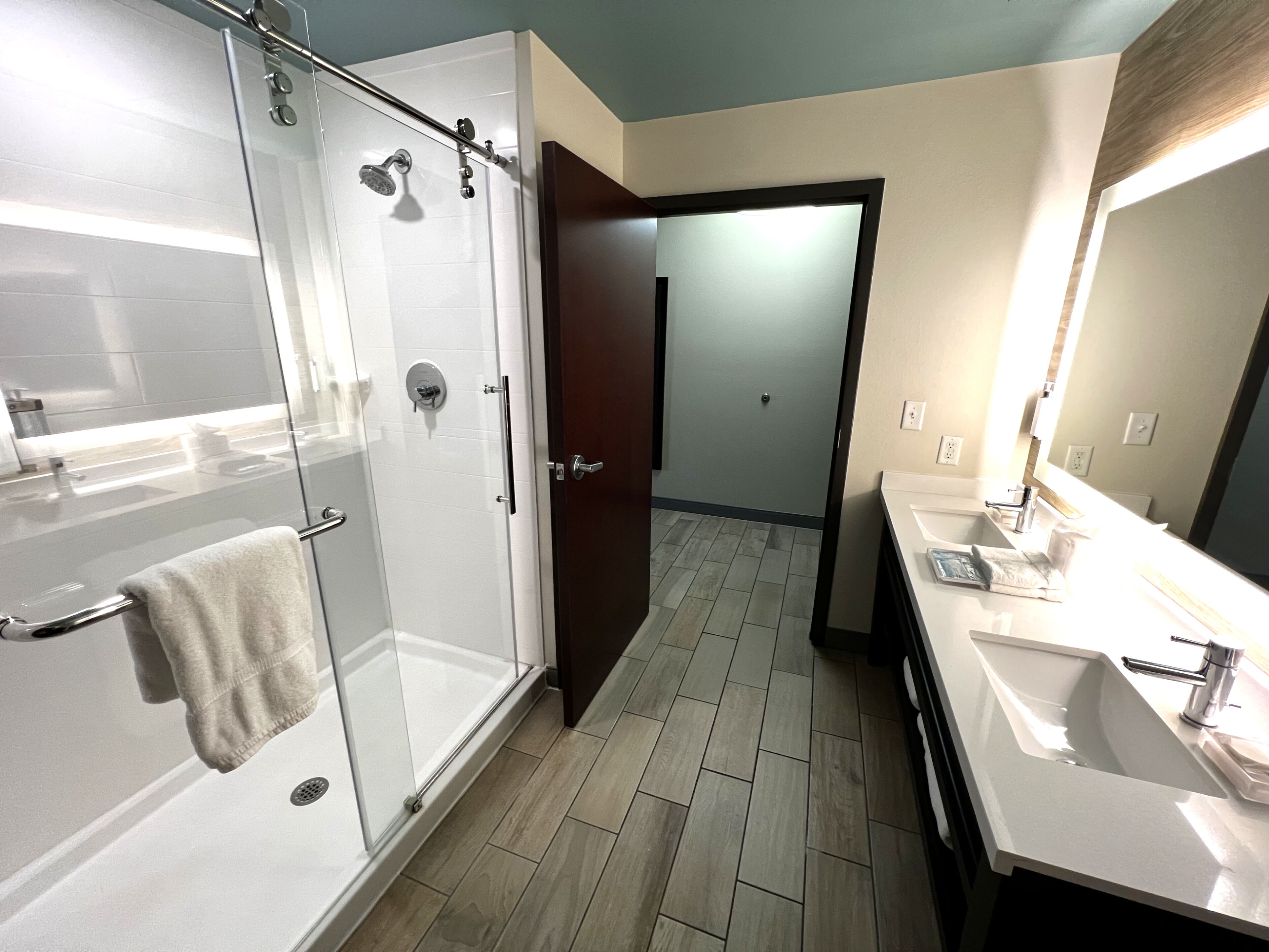 A modern bathroom with a glass-enclosed shower, a separate sink area, and a walk-in shower.