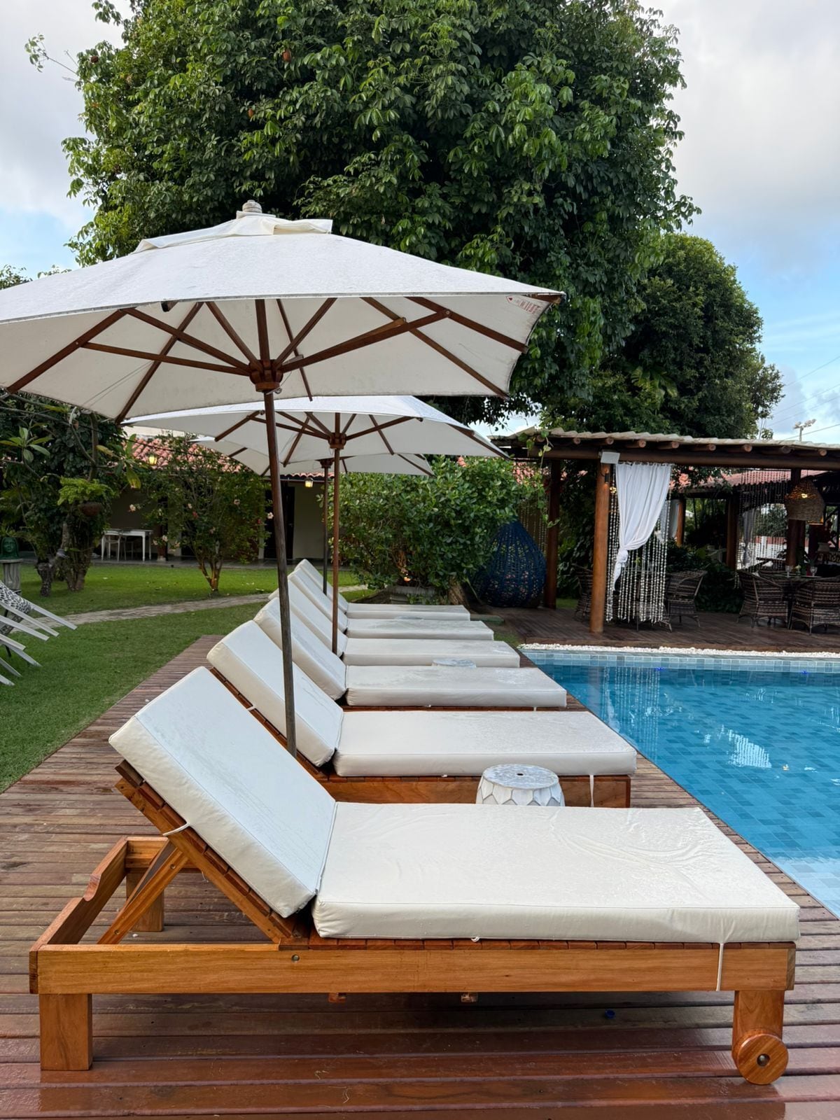 A poolside area with lounge chairs and an umbrella.