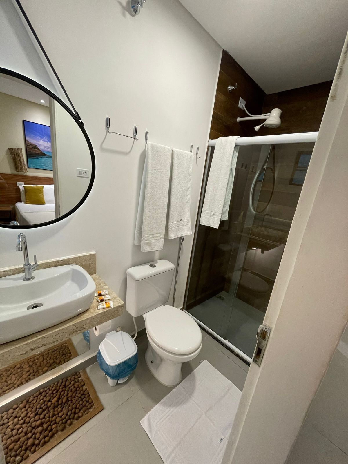 A modern bathroom with a sink, toilet, and glass shower enclosure.