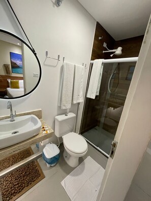 Un baño moderno con lavabo, inodoro y cabina de ducha de vidrio.