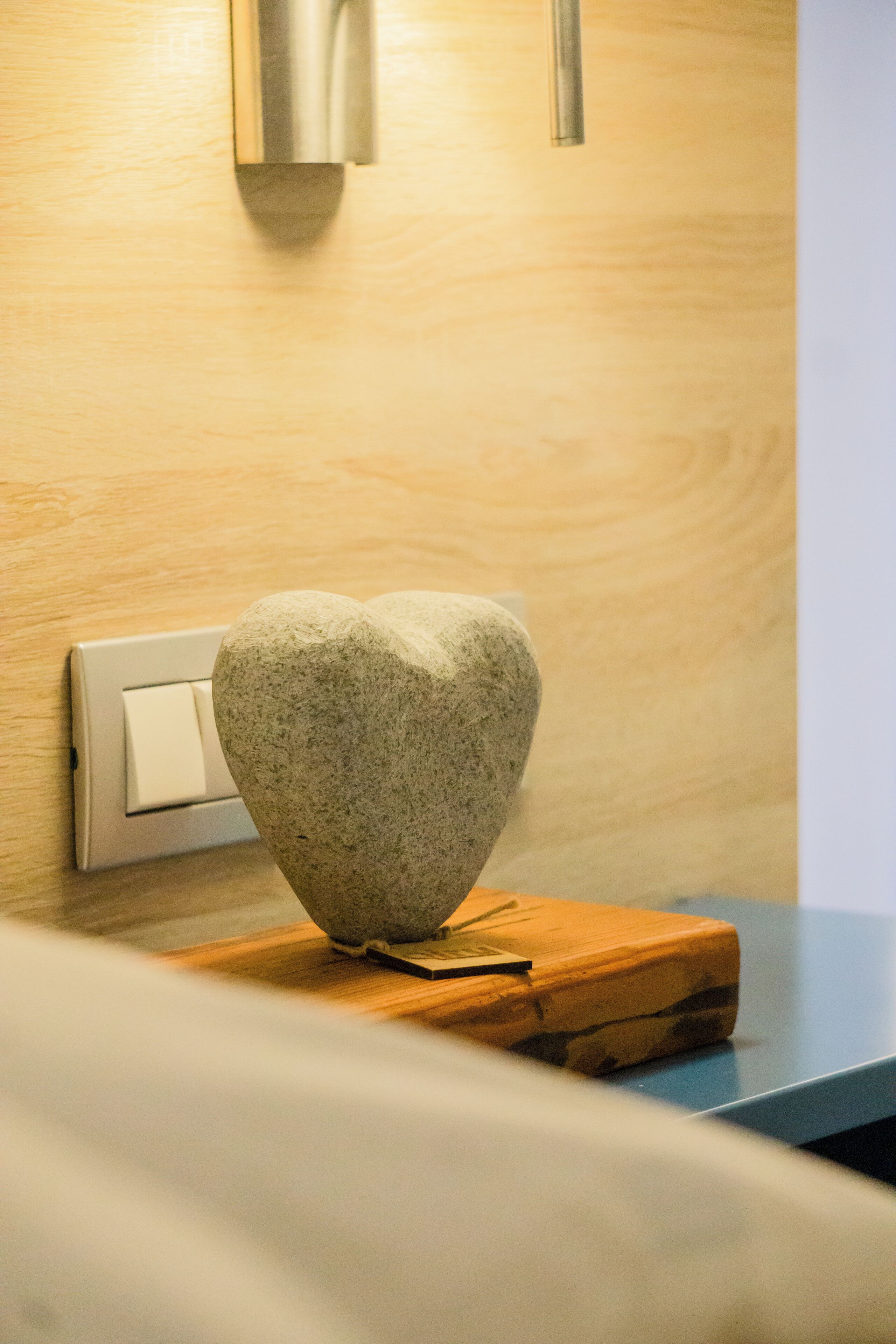 A stone sculpture on a wooden platform, a switch, and a light fixture on a wall.