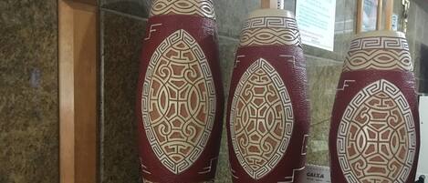 Trois vases décoratifs aux motifs géométriques, présentés sur une étagère.