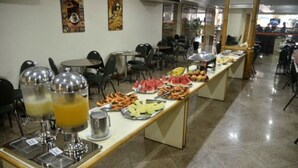 A buffet setup with various food items and drinks. - Hotel Grão Pará (Belém)