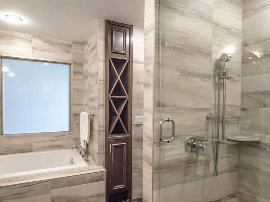 A modern bathroom with a glass-enclosed shower, a freestanding bathtub, and a vanity with a mirror.