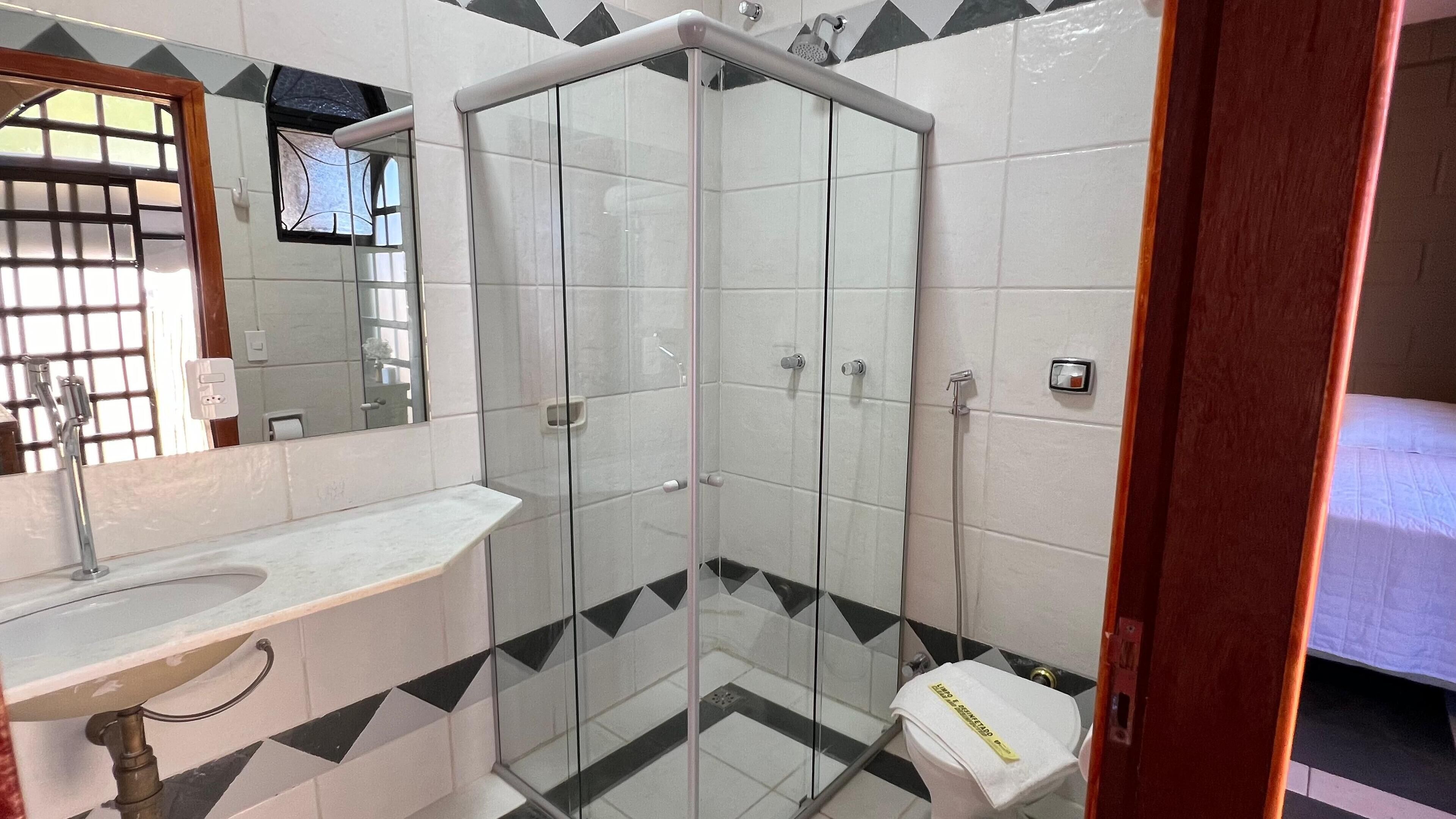 Een badkamer met een douchecabine, een wastafel en een toilet.