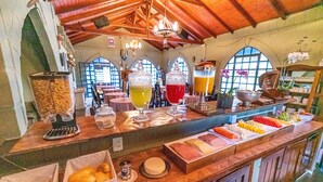 A breakfast buffet with various food items and beverages. - Pousada Camelot (Alto Paraíso de Goiás)
