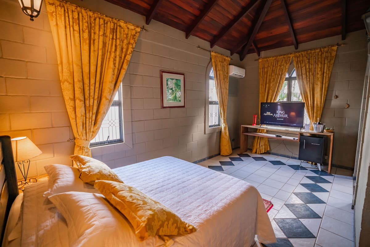 A hotel room with a bed, a desk, and a TV.