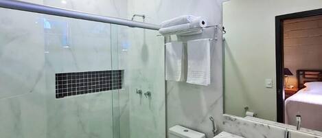 Un baño moderno con ducha de vidrio, lavamanos de mármol y techo de madera.