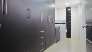 Una cocina moderna con armarios oscuros, encimeras blancas y un elegante salpicadero.