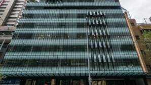A modern skyscraper with a glass facade and a prominent entrance. - StayIcon Serviced Apartment On Collins (Melbourne)
