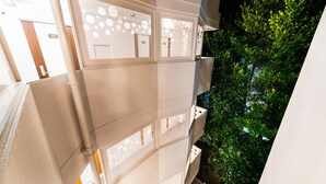 Un immeuble à plusieurs étages, doté de balcons et offrant une vue sur la verdure.
