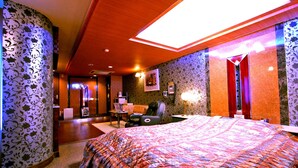 Een hotelkamer met een groot bed, een bureau, een stoel en een telefoon.