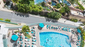 A large outdoor swimming pool with multiple lounge areas and palm trees. - Marina Hawaii Vacations at the Ilikai Tower (Honolulu)