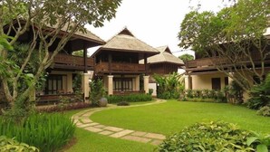 A traditional-style building with multiple balconies and a well-maintained garden. - Pai River Corner Resort (Pai)