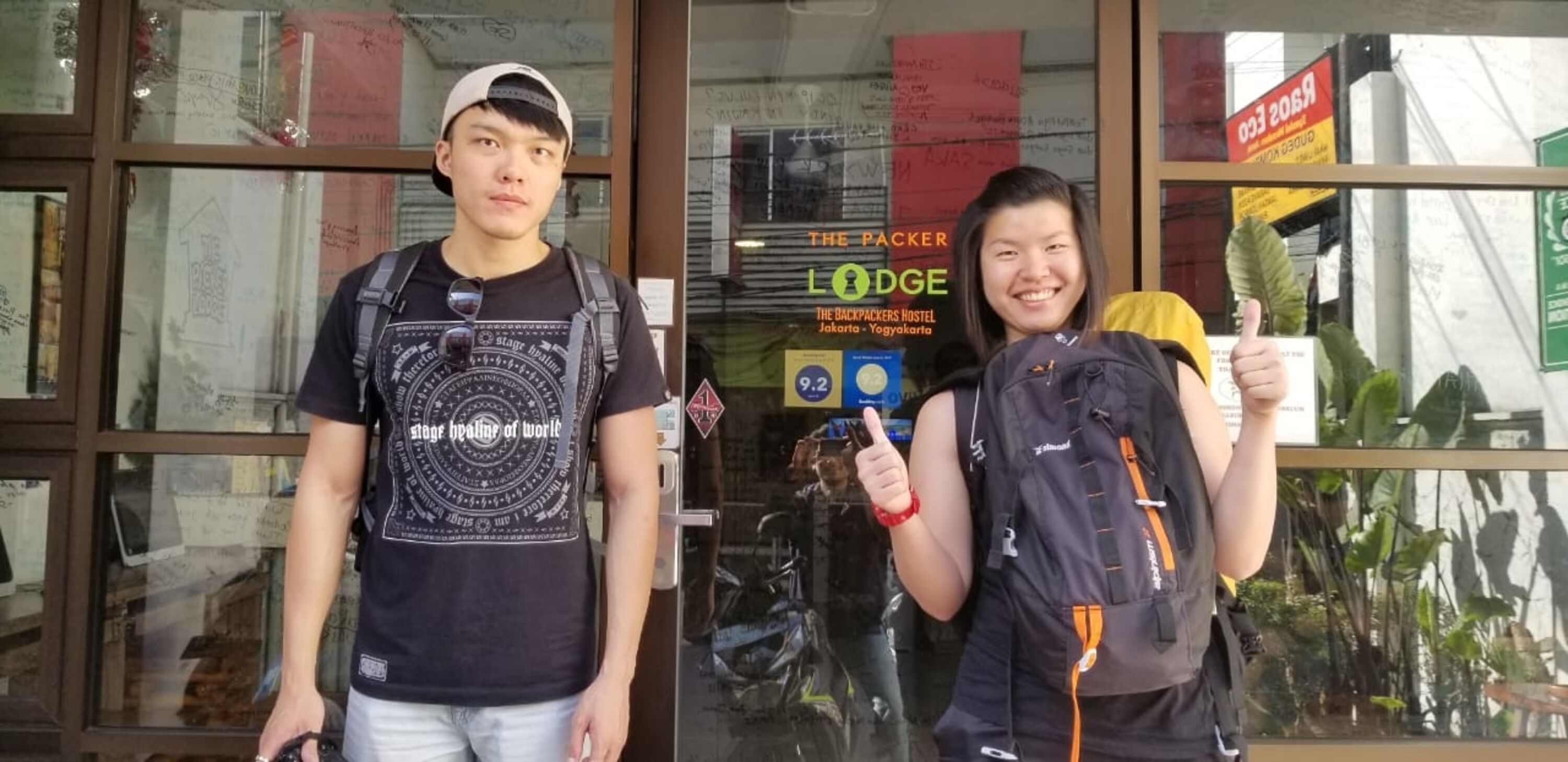 Two people standing in front of a building with a sign that reads "The Packer Lodge".