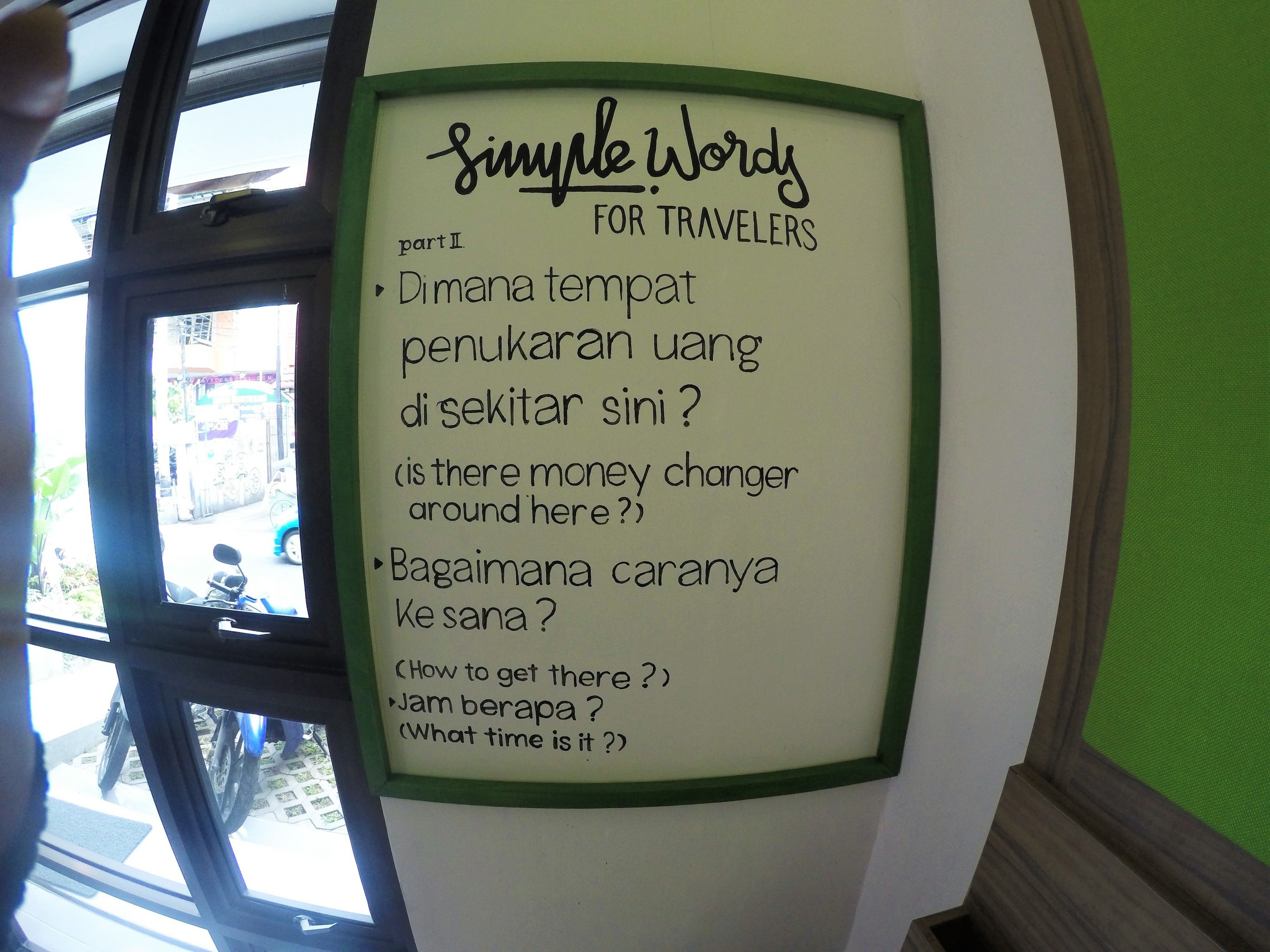 A sign with simple words for travelers, including phrases like "Dimana tempat penukaran uang di sekitar sini?" and "Bagaimana cariannya Ke sana?"