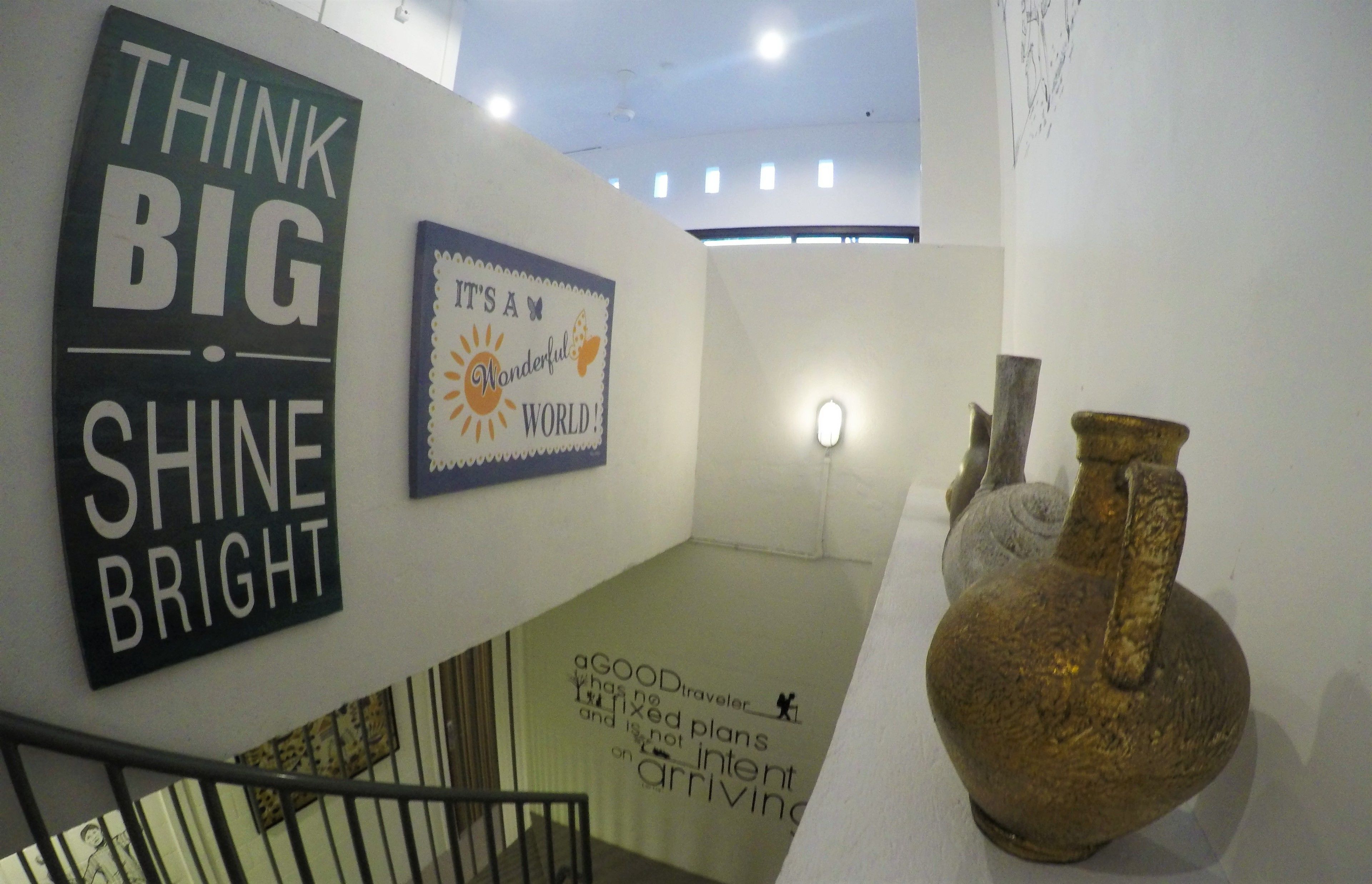 A wall with motivational posters and a decorative vase.
