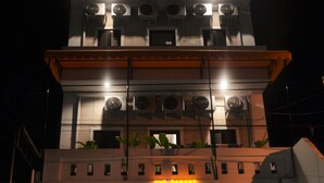 Un edificio con diverse unità di condizionamento, un neon che riporta la scritta "Lodge" e una vetrina con porte in vetro.