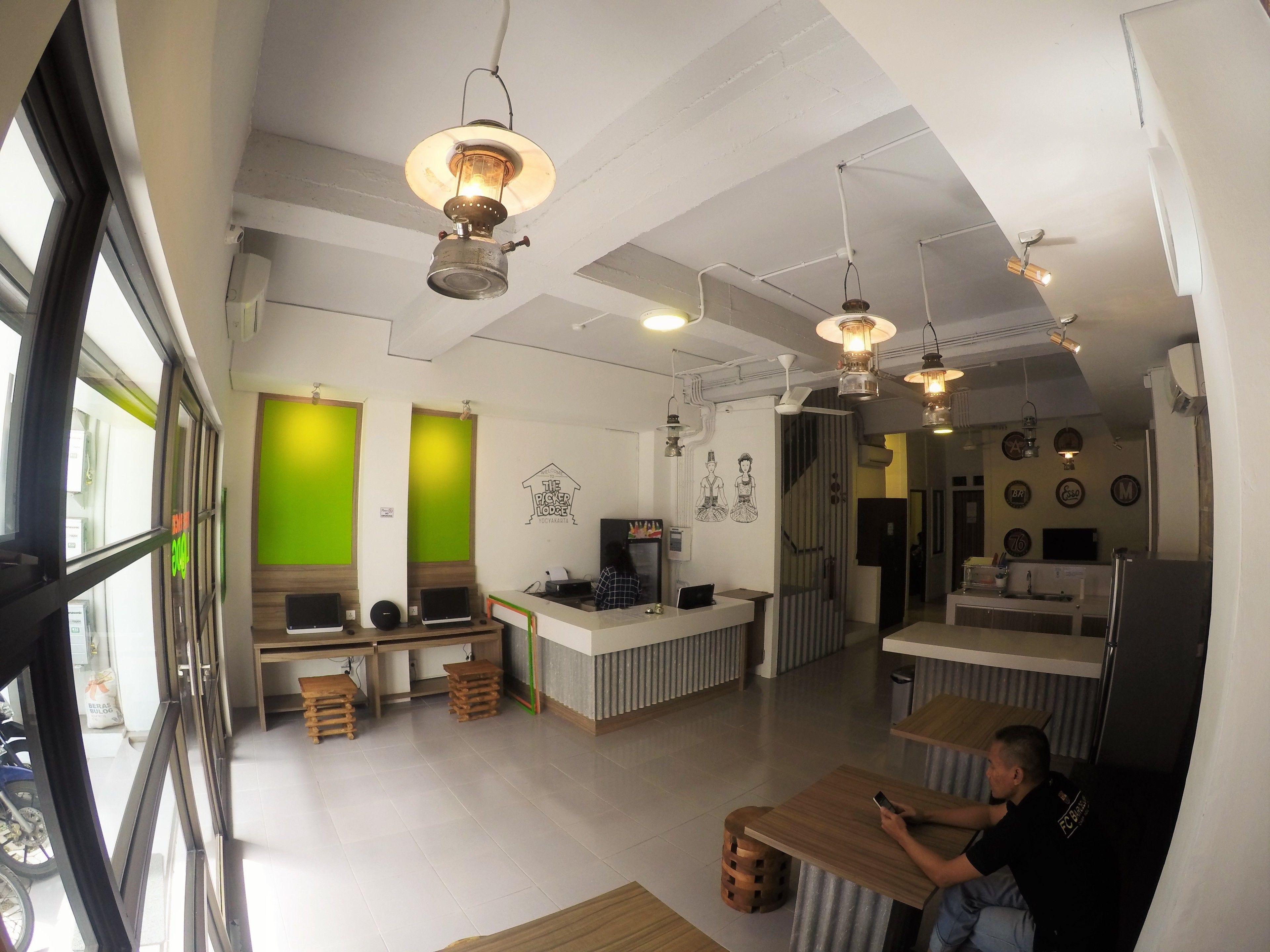 Eine moderne Hotelhalle mit einer Rezeption, einer Sitzecke und Blick auf die Straße.