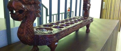 A wooden dragon-shaped incense burner on a table.