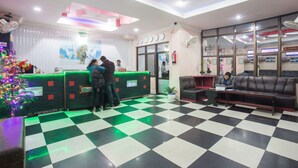 A reception area with a checkered floor, a Christmas tree, and a reception desk. - Hotel Jalsa (Dhangadhi)