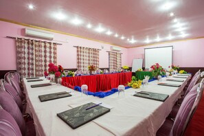 A conference room with a long table, chairs, and a projector screen. - Hotel Jalsa (Dhangadhi)