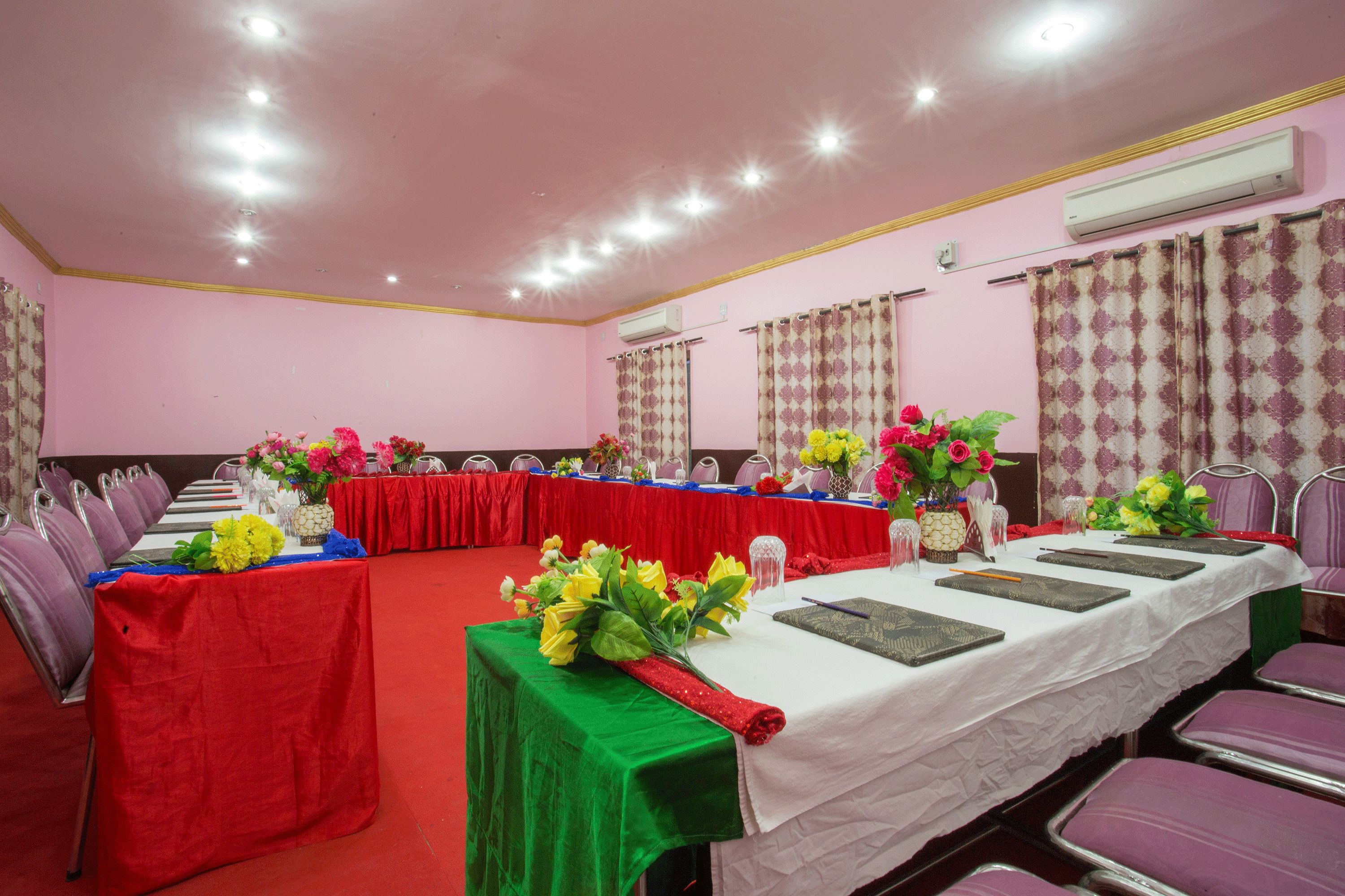 A conference room with a long table, chairs, and floral centerpieces.