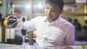 A person pouring a drink into a glass. - Hotel Jalsa (Dhangadhi)