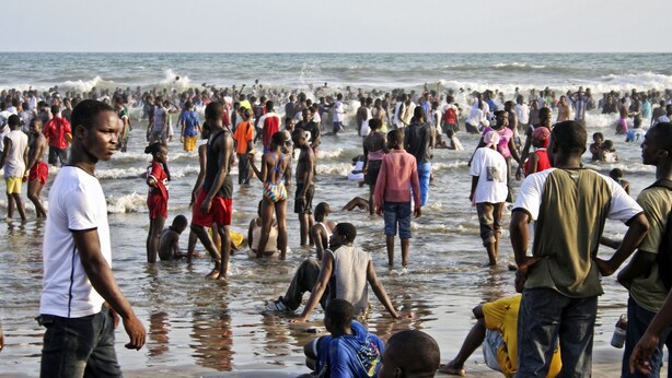 A crowded beach with people in the water and on the shore. - Adinkra Lodge (Accra)