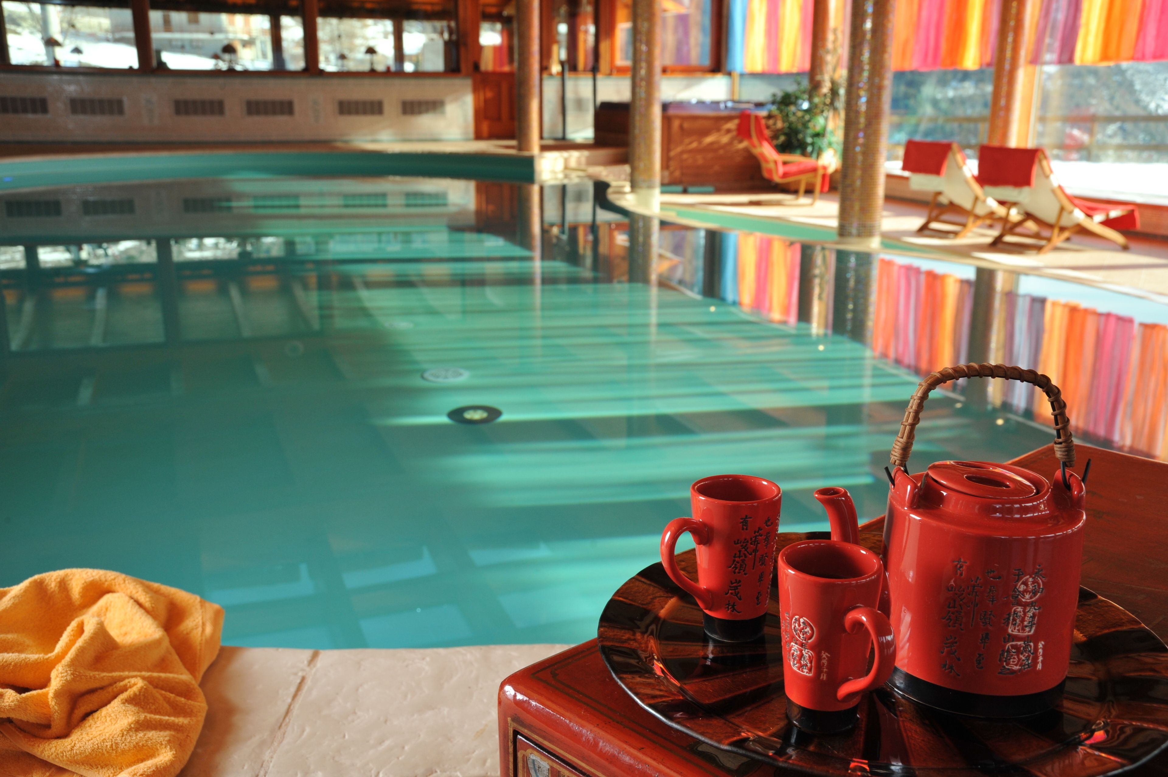 Une piscine avec une terrasse en bois et des chaises longues.