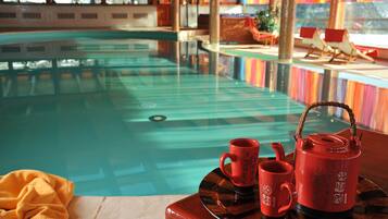 Une piscine avec une terrasse en bois et des chaises longues.