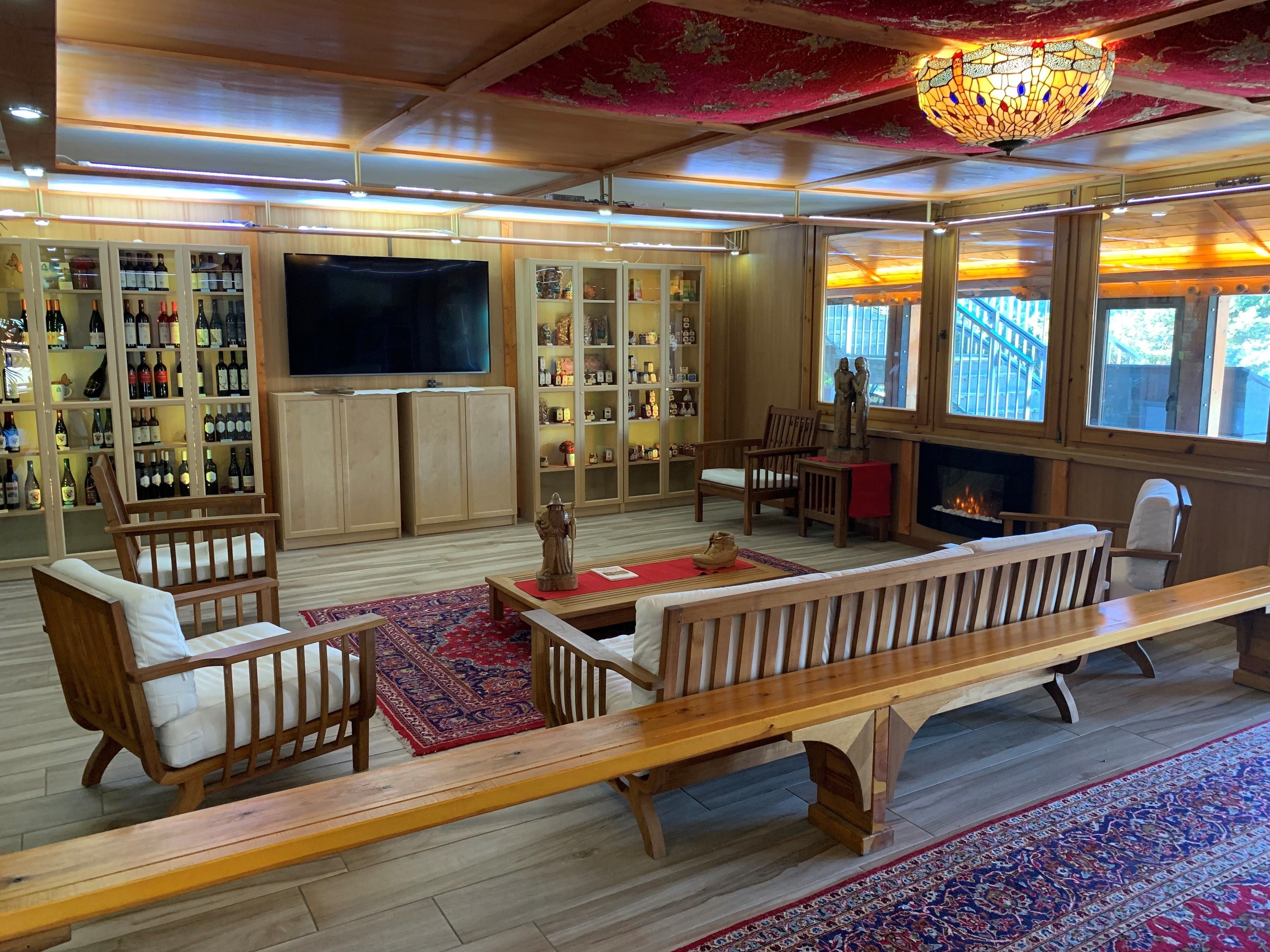 Una sala de estar acogedora con muebles de madera, un televisor grande y una chimenea.