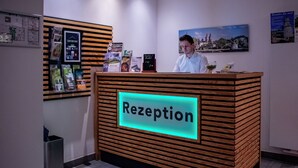 Ein Empfangsschalter mit einem Schild mit der Aufschrift 'Rezeption' und einem digitalen Display.