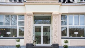 Ein Gebäude mit einem prunkvollen Eingang, großen Fenstern und verzierten Säulen.