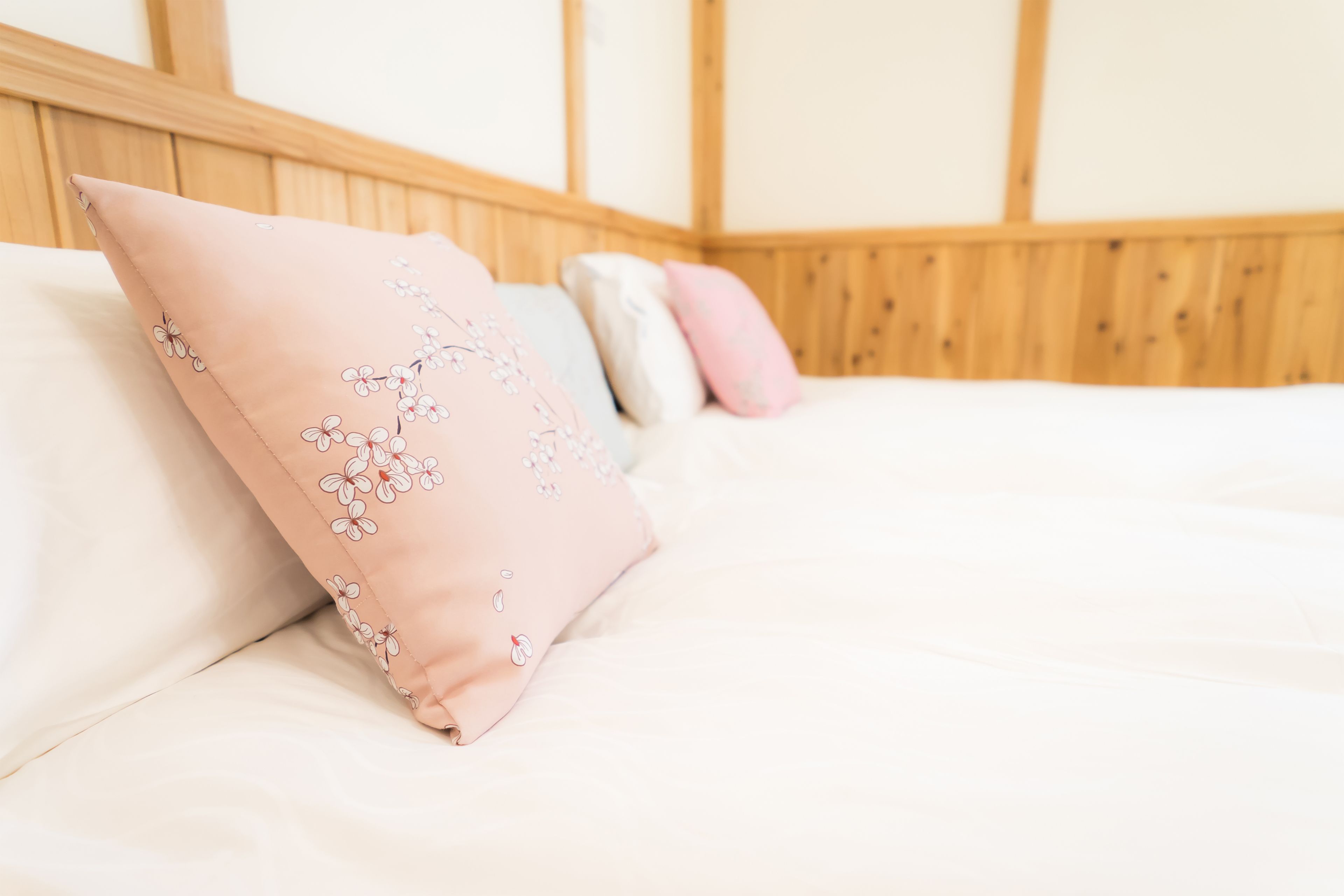 Una cama con cabecera de madera y varias almohadas.