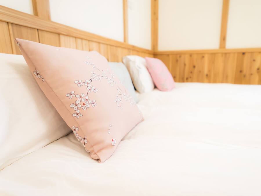 Una cama con cabecera de madera y varias almohadas.