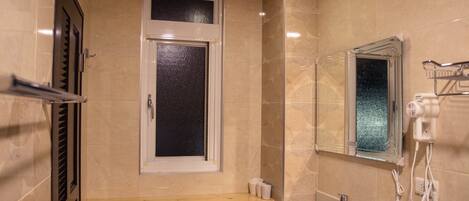 A bathroom with a sink, mirror, and window.