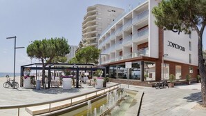 Een modern hotel met terras, zwembad en uitzicht op zee.