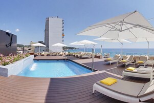 Una piscina al aire libre de temporada, sombrillas