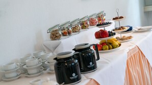 A buffet table with various food items, including fruits, nuts, and pastries, and several coffee pots and tea cups. - Nassauer Hof Limburg (Limburg an der Lahn)