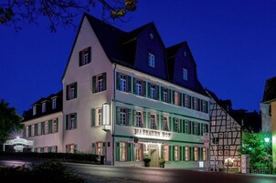 Un hotel europeo tradicional con un cartel llamativo, múltiples ventanas y un estilo arquitectónico clásico.