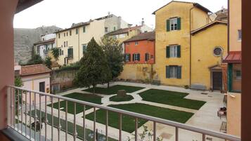 A courtyard with a geometric lawn design, surrounded by buildings with varied architectural styles and colors.