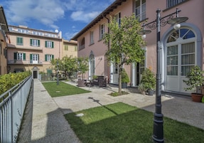 Un patio con un sendero empedrado, césped verde y plantas en macetas.
