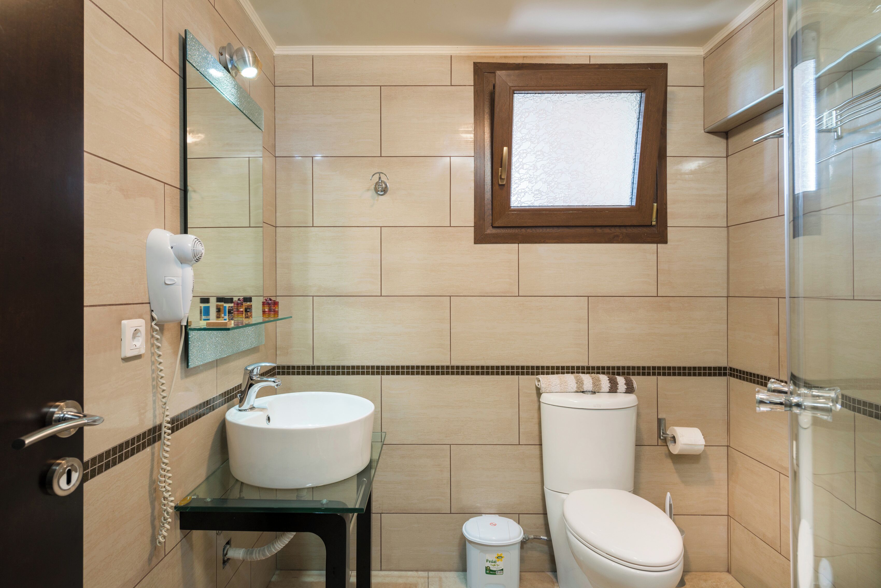 A bathroom with a sink, toilet, and a mirror.