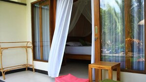 A room with a bed, a small table, and a bench. - Arjuna Homestay (Pemuteran)