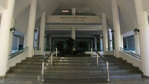 Un escalier menant à un hall d’entrée où est affiché un panneau indiquant « Greater Mekong Lodge ».