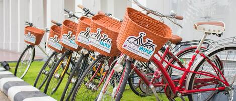A row of bicycles with baskets labeled "Fortune Bike" parked along a curb.