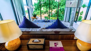 Une chambre d’h ôtel avec un lit, deux lampes, une boîte de mouchoirs et un livre sur la table de chevet.